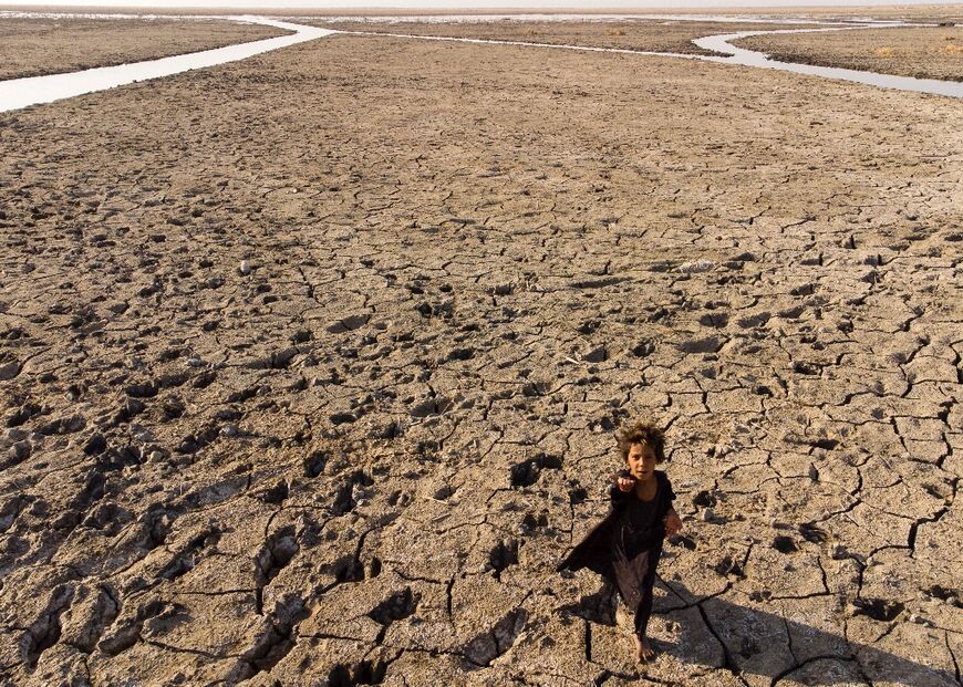 Heatwaves, drought and sandstorms have hit Iraq, one of the countries most threatened by climate change. A child walks though dried marshes in southern Dhi Qar province on August 23, 2022