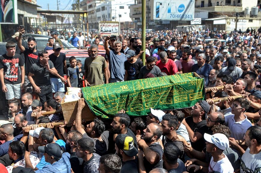 Mourners march with the body of one of the victims who drowned in the shipwreck of a migrant boat that sank off the Syrian coast, at his funeral in northern Lebanon's port city of Tripoli