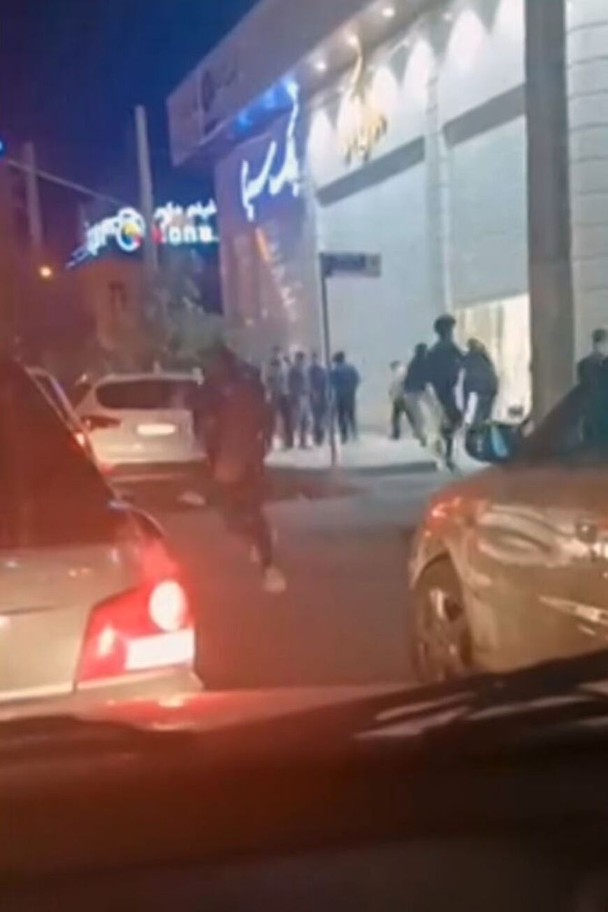 This grab taken from a UGC video posted online on Thursday shows Iranians running past traffic as gunfire is heard in the southeastern city of Kerman