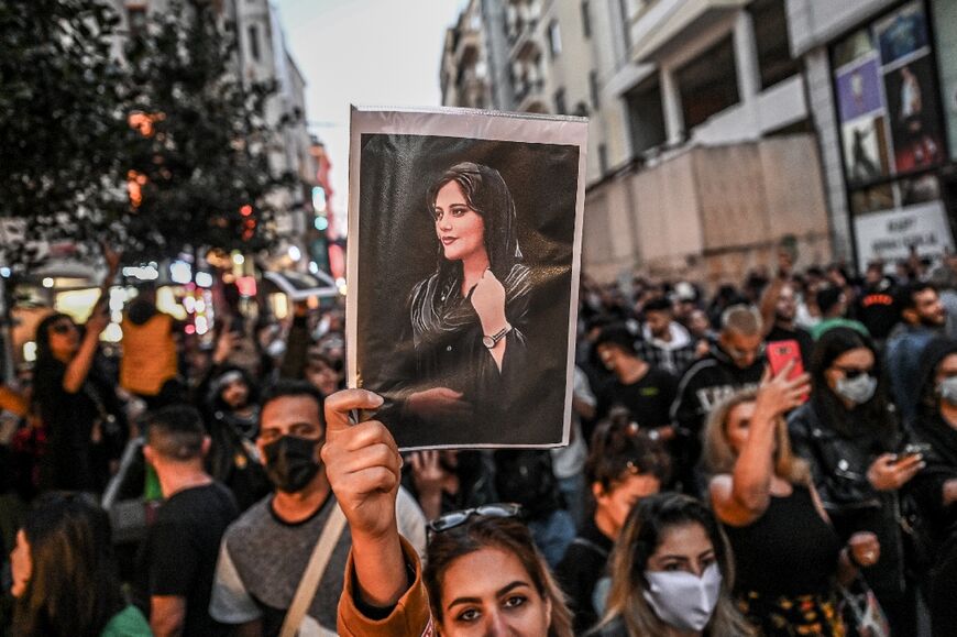 A protester in Istanbul holds aloft a photograph of Mahsa (Jhina) Amini, the young Kurdish woman who died in the custody of Iran's morality police who arrested her for an alleged infraction of the country's mandatory dress code for women