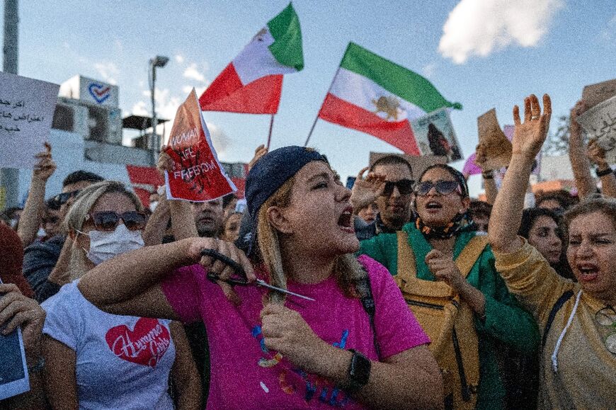 A protestors cuts her hair during a demonstration in support of Iranian women, in Istanbul on October 2, 2022
