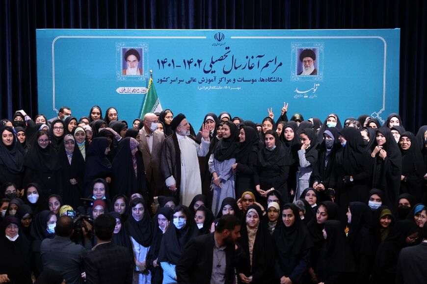 Iran's ultraconservative President Ebrahim Raisi poses for a group photograph with female students at Tehran's Al-Zahra university at the start of the new academic year