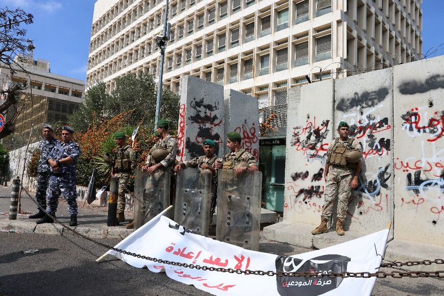 Policemen stand guard during a protest outside  Lebanon's Central Bank in Beirut