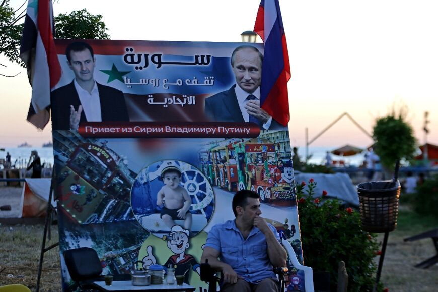 Syrian President Bashar al-Assad, on the left, and Russian President Vladimir Putin, are pictured on a poster with the message "Syria stands with the Russian Federation", in Syria's port city of Tartus, seen on July 24, 2022