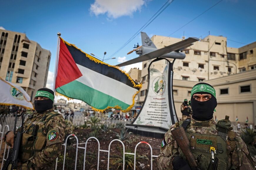 Members of the Ezzedine al-Qassam Brigades, the armed wing of the Palestinian Hamas movement, stand guard around a model of the 'Shehab' drone on a roundabout in Gaza City September 21, 2022