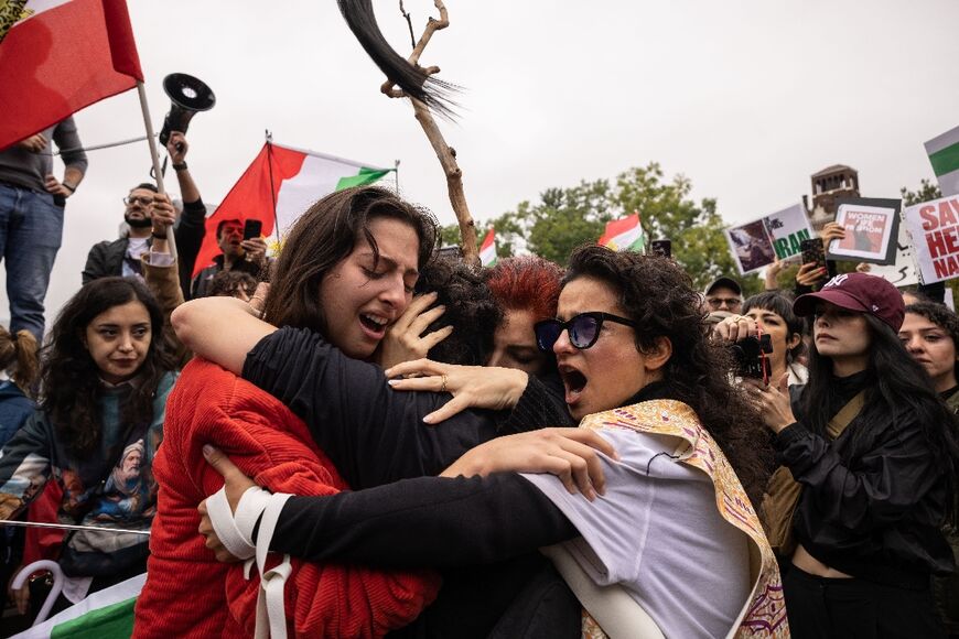 Activists in New York hug each other after cutting their hair in protest over the death of Mahsa Amini  in the custody of Iran's notorious morality police 