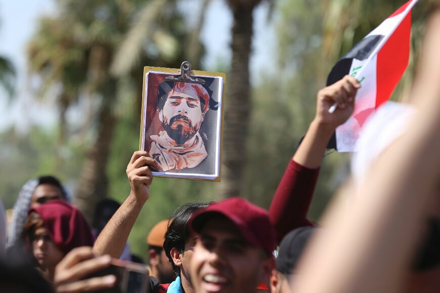 Iraqi anti-government demonstrators carry a picture of a killed protester during a demonstration in Baghdad's Nisour Square