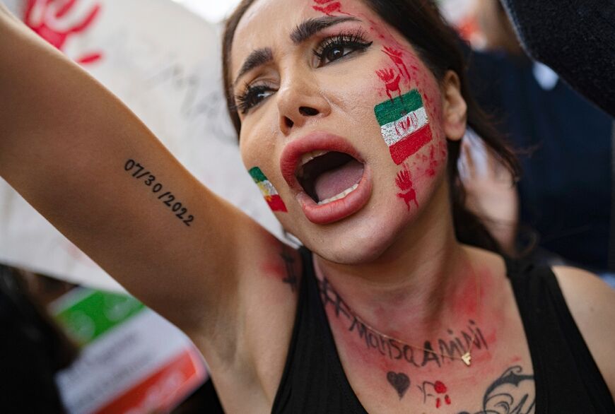 A protester in Turkey with an Iranian flag painted on her face shouts outside the Iranian consulate in Istanbul on October 17