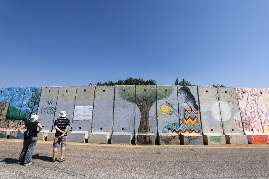 Israeli tourists seen near the northern border wall with Lebanon, close to the Israeli settlement of Shtula