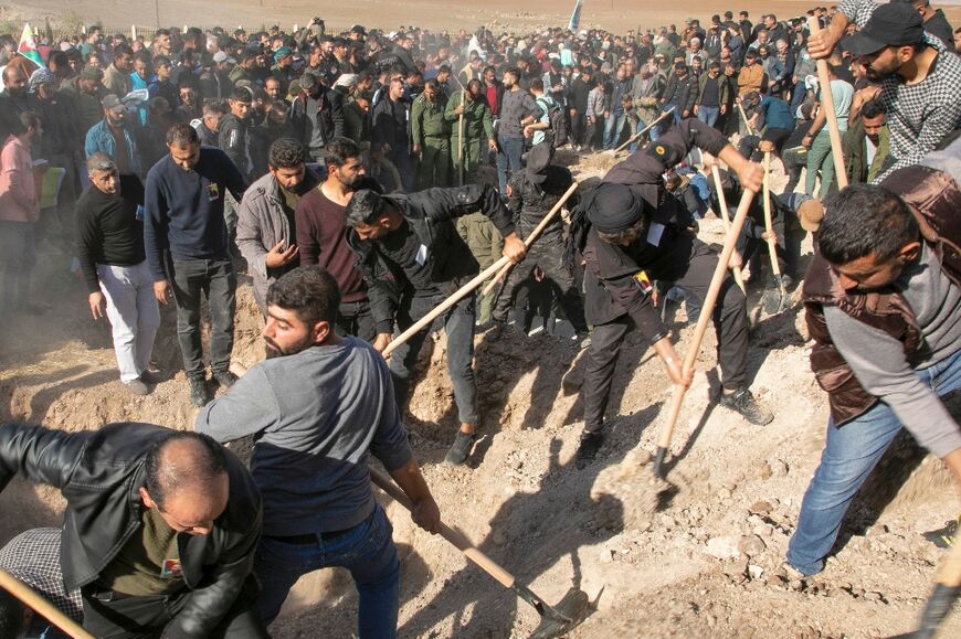 Syrian Kurds dig the graves for people killed in the Turkish air strikes in al-Malikiyah in Syria's northeastern Hasakah province, on November 21, 2022
