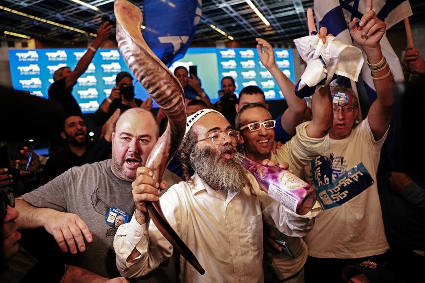 A supporter of Israel's Likud party holds a Shofar, a musical instrument made of a ram's horn, at the party's campaign headquarters in Jerusalem on November 1, 2022, after the end of voting in the fifth national election in less than four years