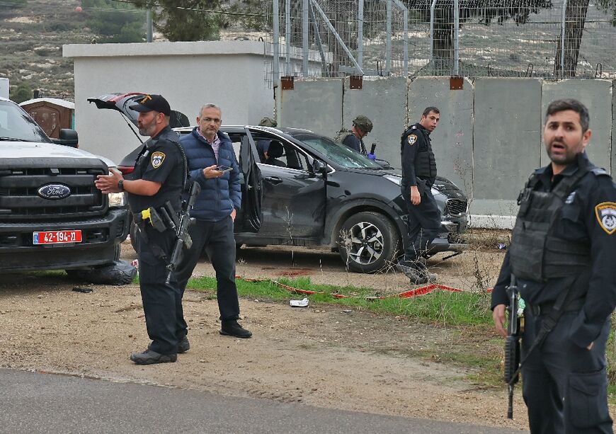 Israeli forensic scientists inspect the vehicle used in a suspected Palestinian car-ramming attack that seriously wounded a woman before the driver was shot dead
