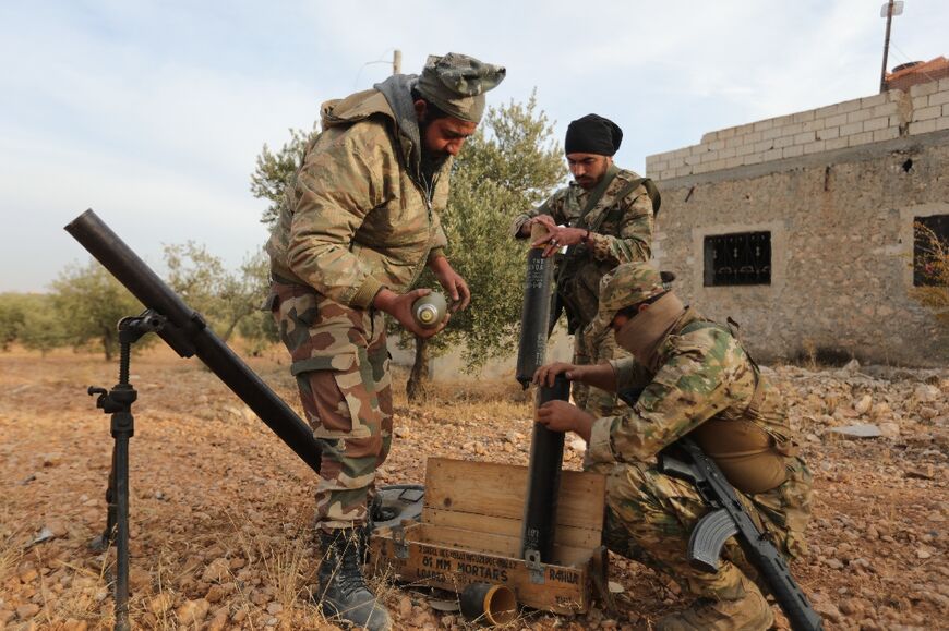 Turkey-backed Syrian fighters load a mortar close to the border with Turkey 