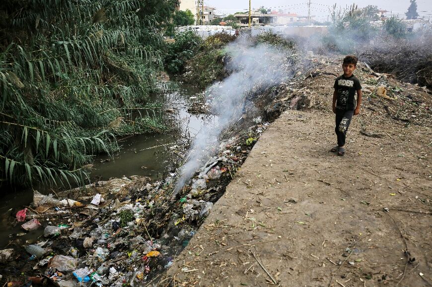 A child stands next to a polluted water source at a make-shift camp for Syrian refugees in Talhayat, near Bebnine, north Lebanon 