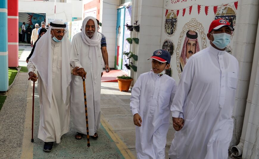 Bahraini men arrive to vote at a polling station on the island of Muharraq