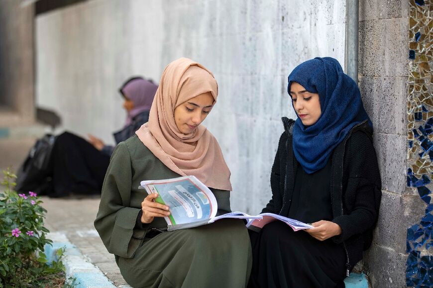 Yemeni women read at a university in the city of Taez