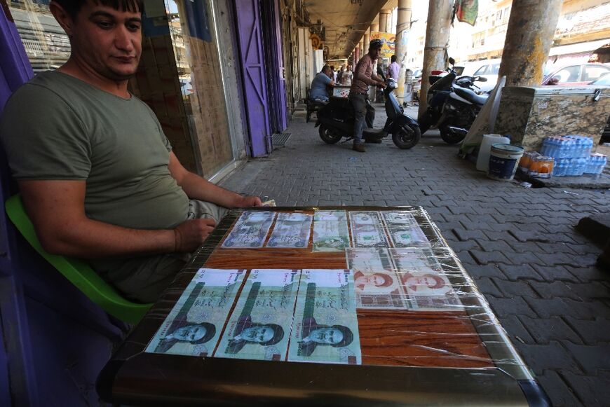An Iraqi peddler displays Iranian currency for sale in Baghdad in 2018