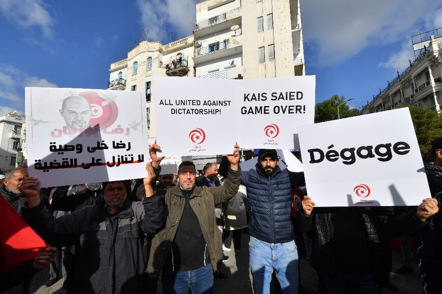 Tunisian demonstrators raise protest placards calling on the president to step down as they take to the streets of the capital Tunis