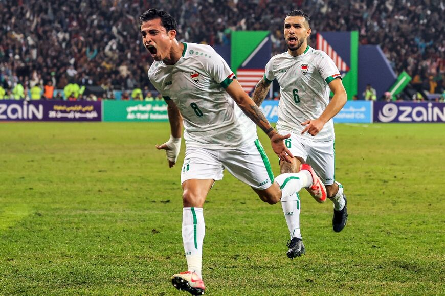 Iraq's midfielder Ibrahim Bayesh (L) reacts after scoring against Oman