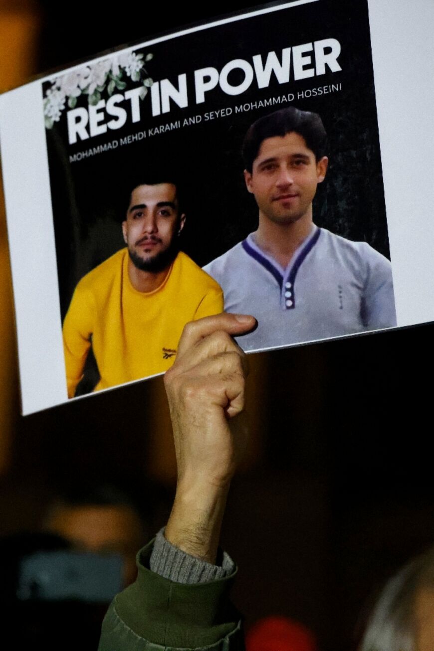 A person in Paris holds a poster with two of those executed over the protests 