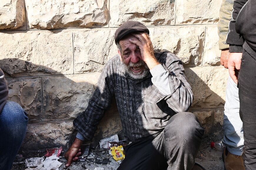 A Palestinian man mourns the death one of those killed during the raid as residents began the funeral processions
