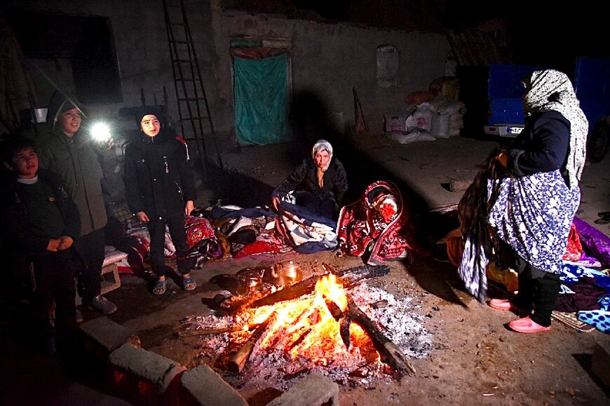 Iranians gather around a fire after the quake hit amid freezing winter conditions