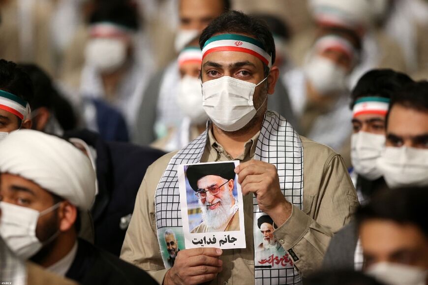 A member of Iran's Basij volunteer paramilitary organisation holds a picture of Ayatollah Ali Khamenei, supreme leader of the 44-year-old Islamic regime