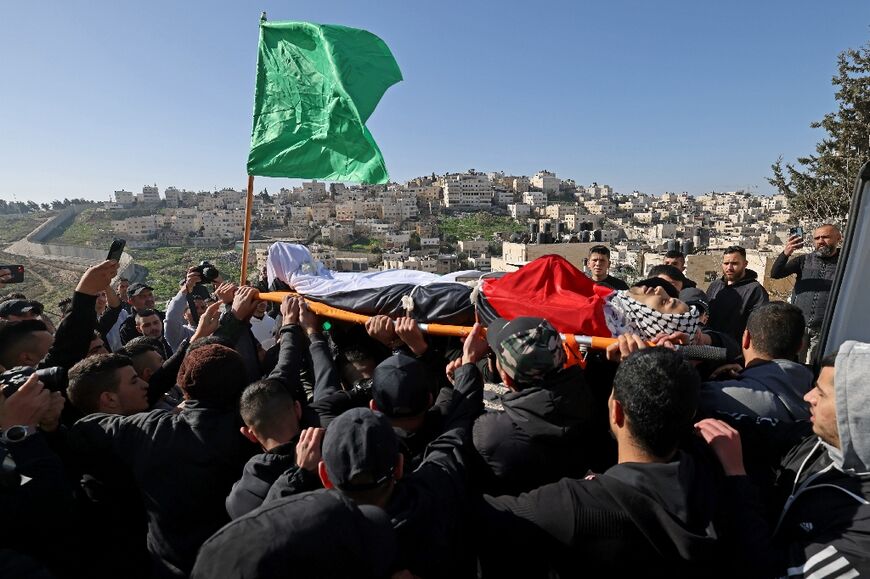 Mourners carry the body of Palestinian youth Yusef Muhaisen, killed by Israeli fire amid clashes, during his funeral in the West Bank town of Al-Ram on January 27
