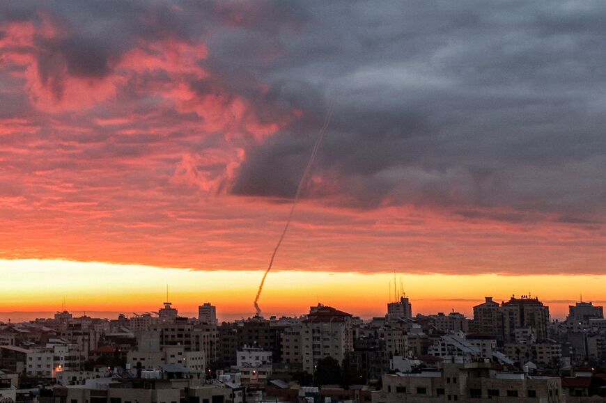 Smoke plumes are visible as rockets are fired from Gaza City towards Israel at sunrise on February 23, 2023