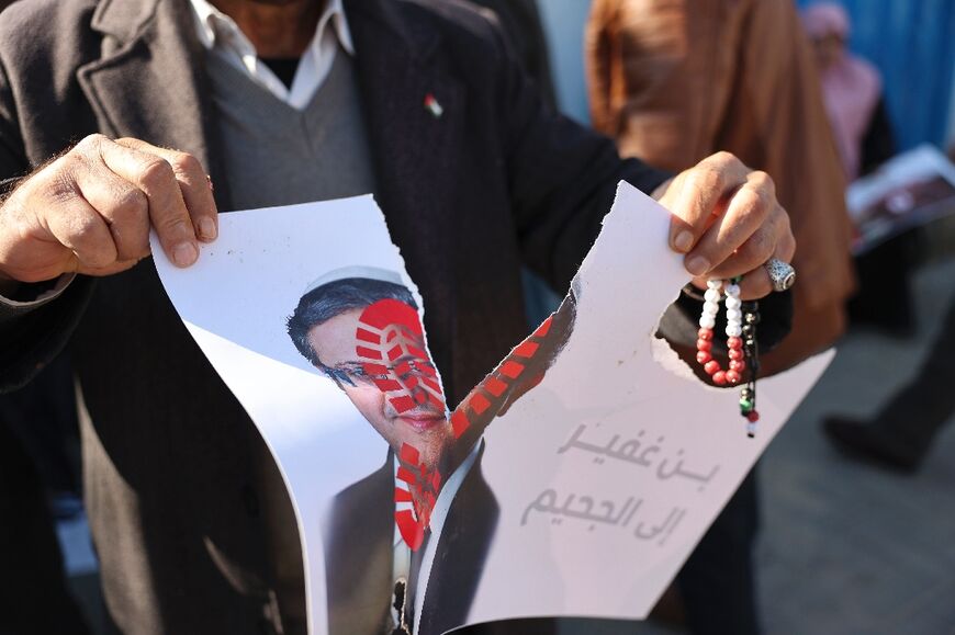 Palestinian protesters tear a poster depicting Itamar Ben-Gvir during a rally in Gaza on January 11, 2023 