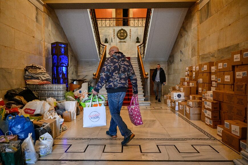 An Athens municipality worker prepares bags with goods provided by Athens citizens to aid Turkey