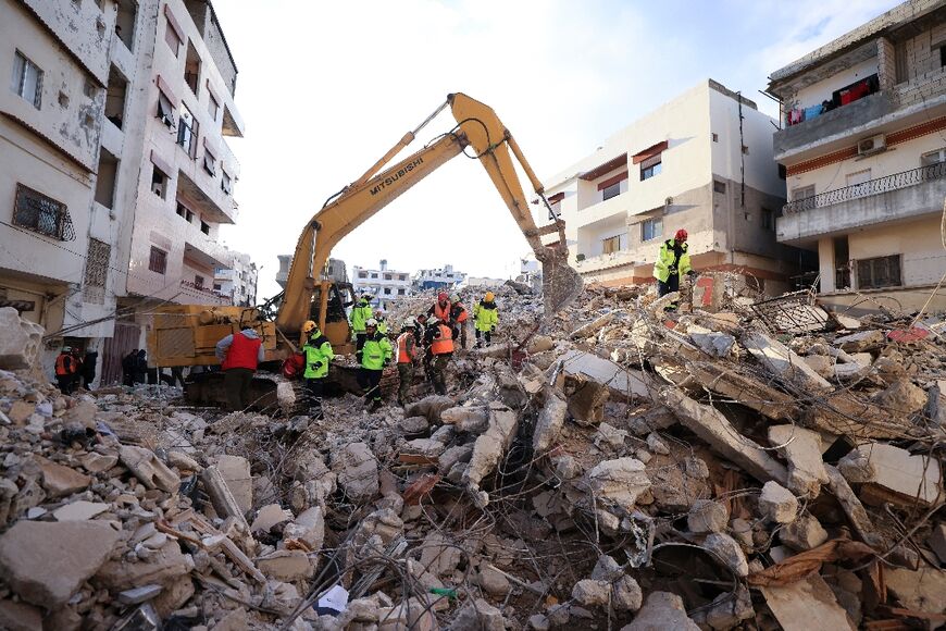 Rescuers sift through the rubble of a collapsed building