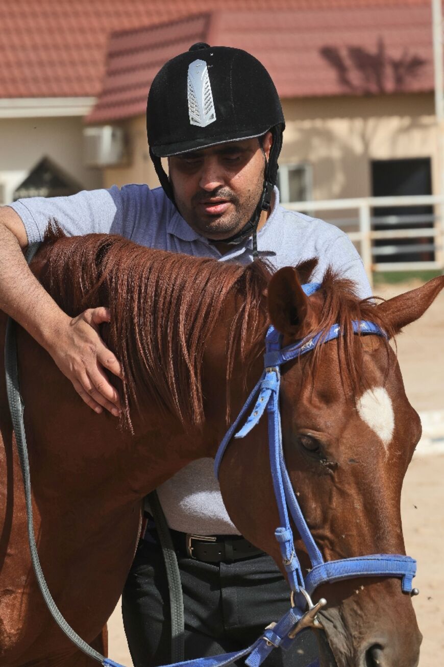 Al-Sharari strokes his ride Star during a training session. The blind showjumper says his love of horses helped him overcome childhood introversion