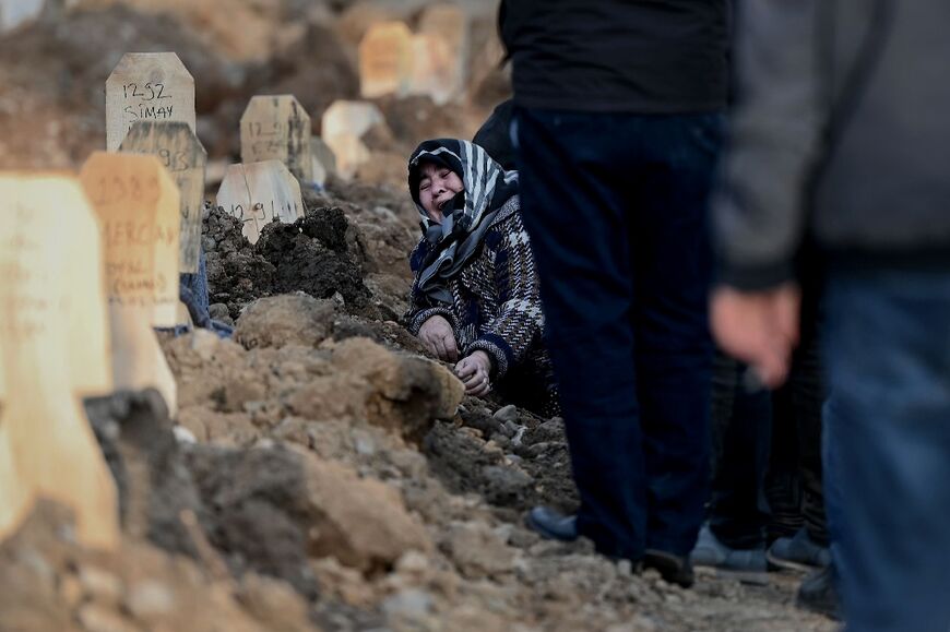 A woman mourns over the grave of her loved ones