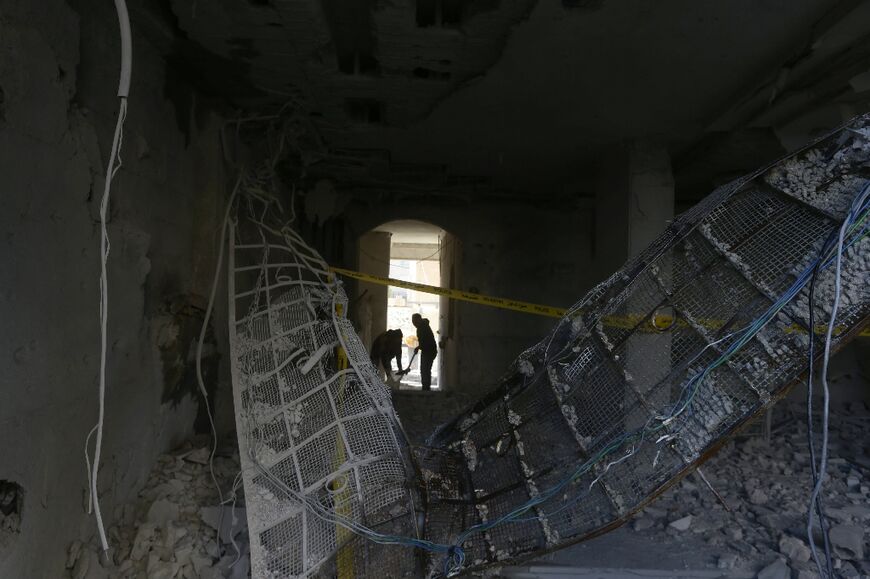 A man sweeps debris from the damage caused by a reported Israeli missile strike in Damascus