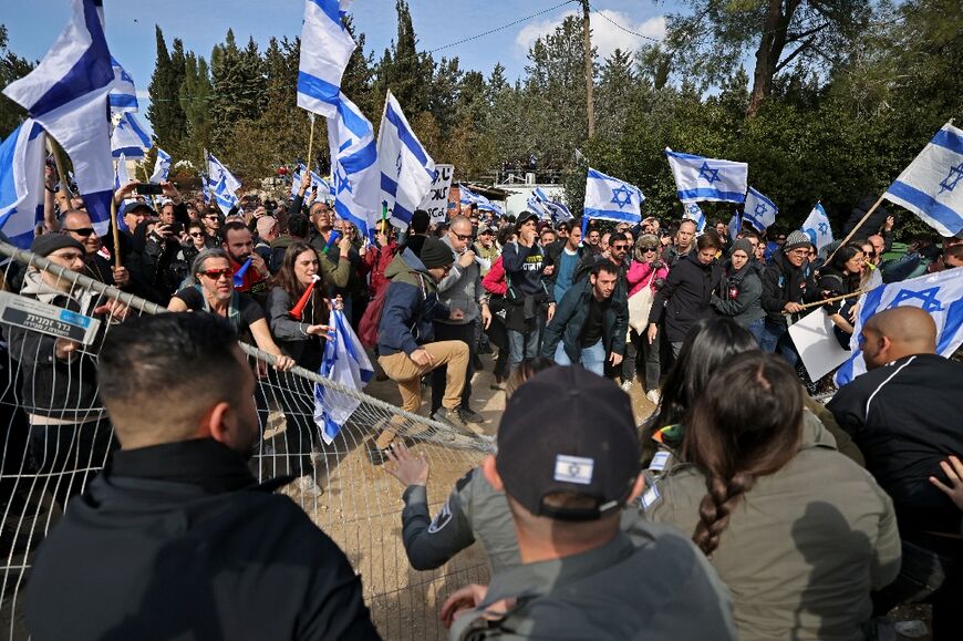 Israeli protesters push a fence outside parliament in Jerusalem on February 13 during a rally against controversial legal reforms 