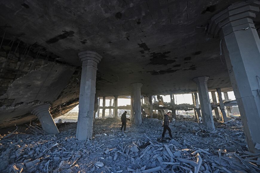 Palestinians inspect a destroyed wedding hall following Israeli strikes in Gaza City, early on February 13, 2023 