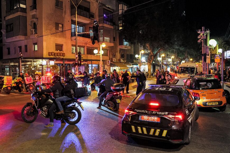 Israeli police, security forces, and paramedics gather at the scene of a shooting attack along Dizengoff Avenue in the centre of Tel Aviv