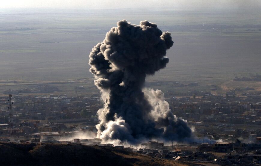 Heavy smoke billows during an operation by Iraqi Kurdish forces backed by US-led strikes against IS in Sinjar town on November 12, 2015