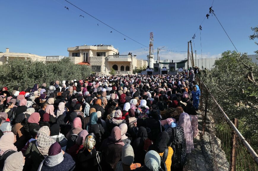 A large crowd forms at an Israeli checkpoint between the occupied West Bank and annexed east Jerusalem as Palestinians wanting to pray at Al-Aqsa are subjected to security checks a Palestinian minister calls "humiliating"