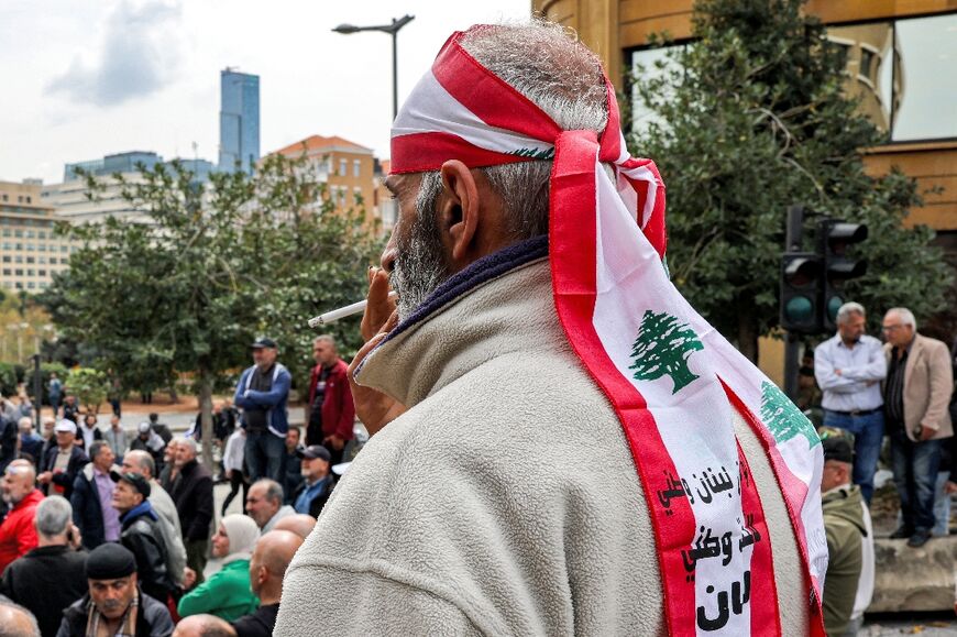 A demonstrator wears a bandana in the colours of the Lebanese flag 