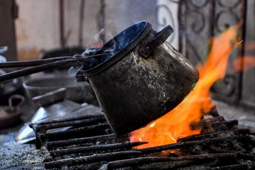 A coppersmith treats a traditional pot used to cook couscous