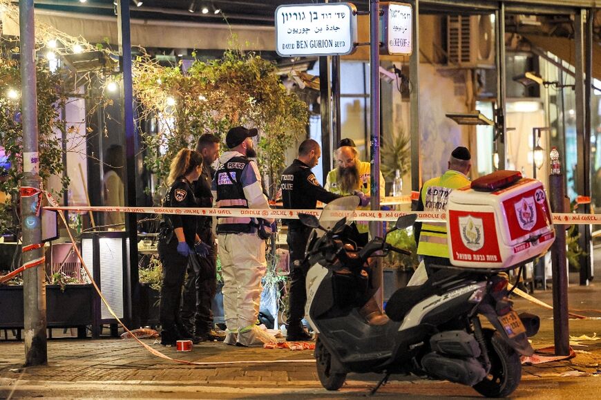 Israeli police, forensics experts, and paramedics at the scene of a shooting attack along Tel Aviv's Dizengoff Avenue 