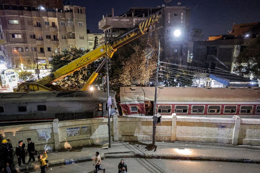 A crane is deployed to lift a derailed train car after an accident at Qalyub station north of the Egyptian capital Cairo