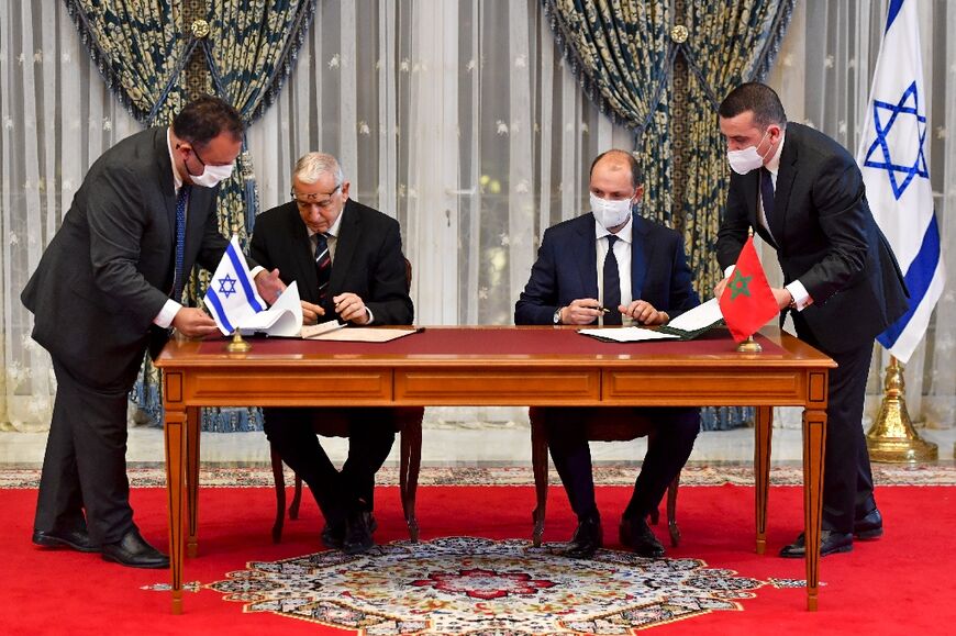 Israel's Population and Immigration Agency chief Shlomo Mor-Yosef (L) and top Moroccan foreign affairs official Mohcine Jazouli sign an agreement in Rabat on December 22, 2020, on the first Israel-Morocco direct commercial flight