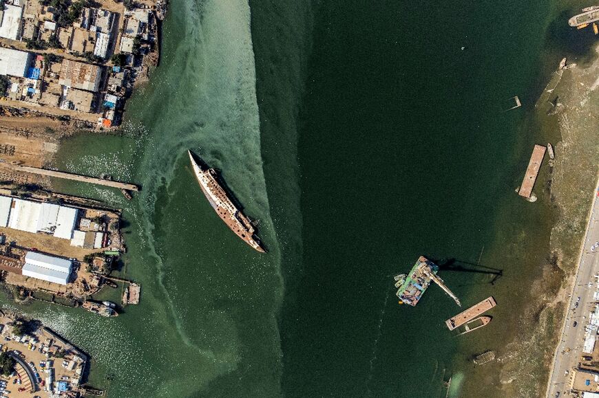The Al-Mansur lies half-submerged, its rusty carcass protruding from the waters of Shatt al-Arab