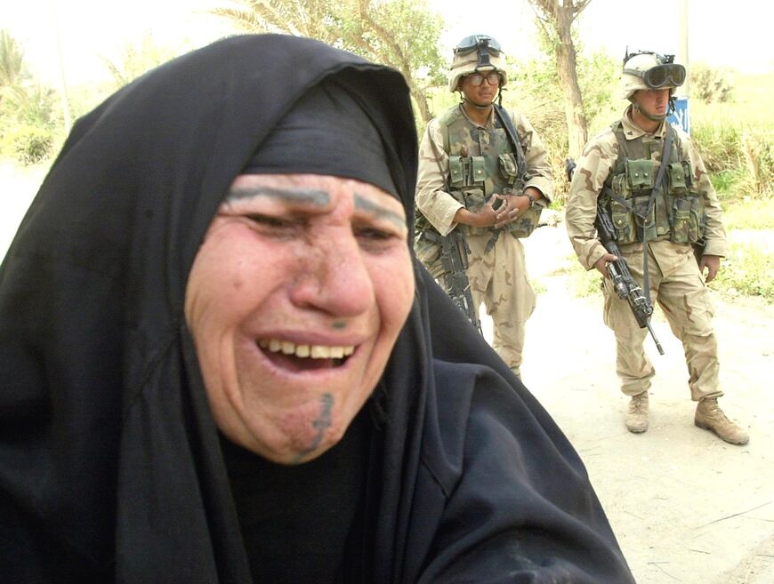An Iraqi woman cries when she is unable to find her two children at the Baghdad psychiatric hospital, as two Marines stand guard, in this file photo from April 12, 2003