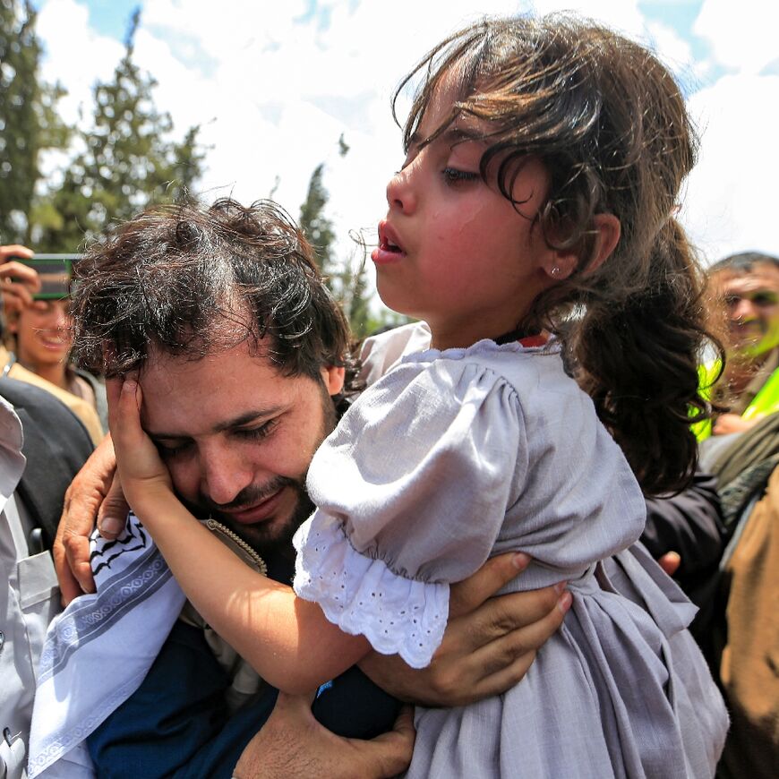 Returning prisoners were embraced as they arrived in Sanaa