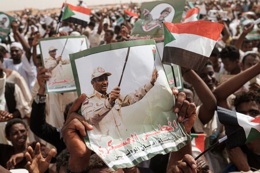 Supporters hold portraits of Mohamed Hamdan Daglo  during a rally in 2019