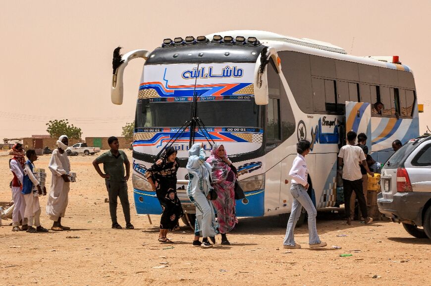 About 300 kilometres northwest of Sudan's capital Khartoum, bus passengers fleeing the country's war rest on the way to Egypt